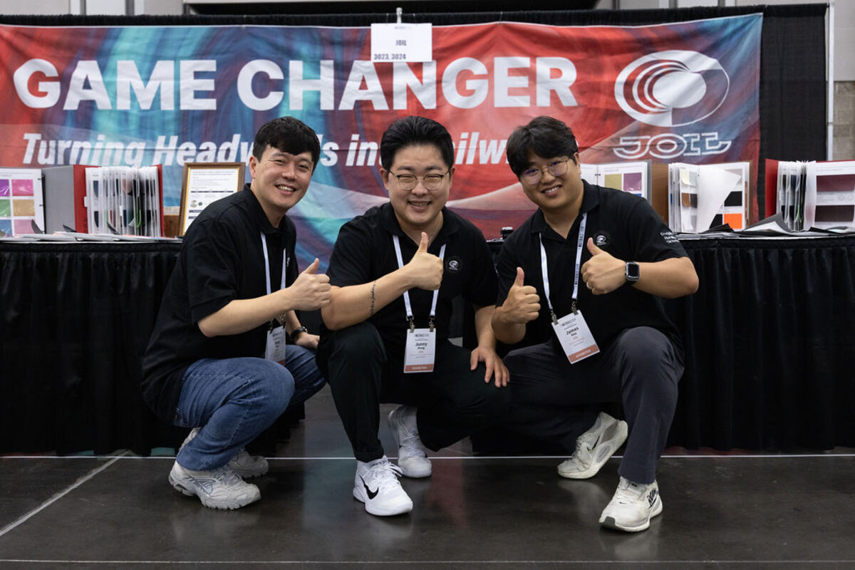 Exhibitors giving a thumbs up in their booth.
