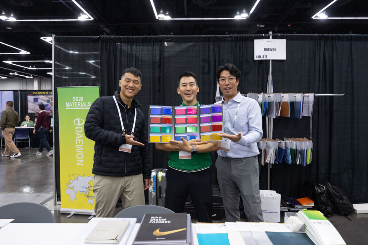 Exhibitors holding up color swatches in their booth.