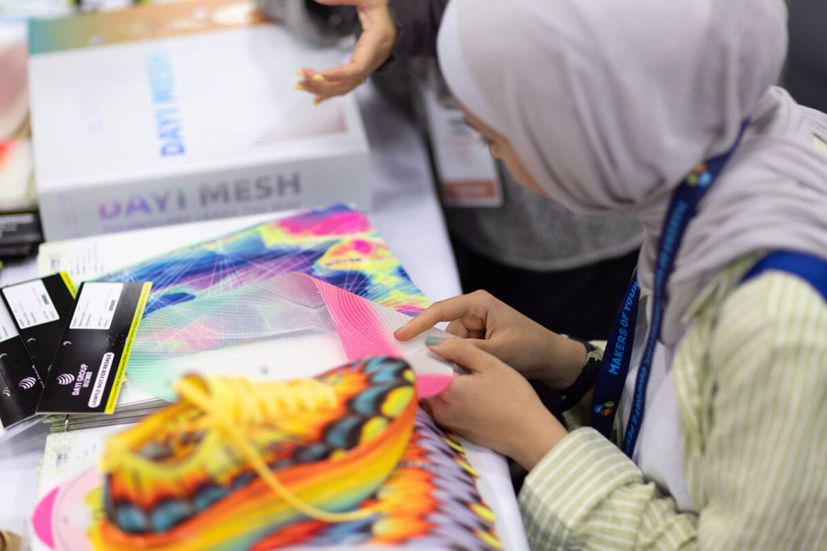 A visitor looking through bright mesh fabric samples at The Materials Show.